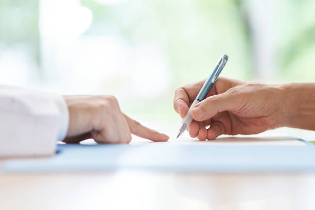 Consent forms with people signing the contract on paper